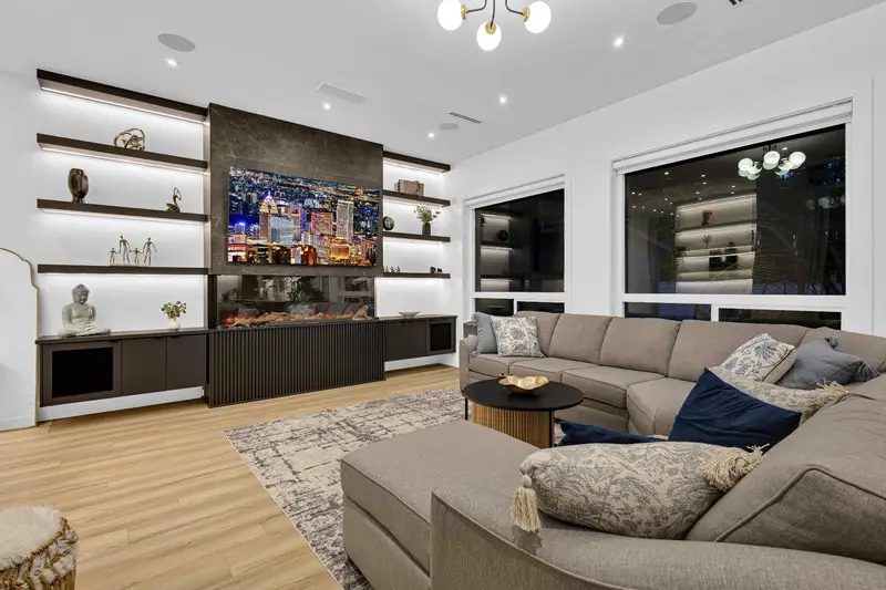 Cozy family room with built-in shelving and LED feature wall in Langley home
