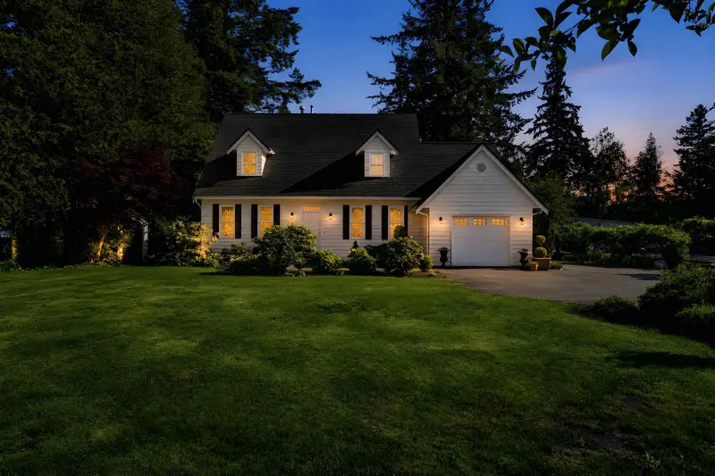Twilight front exterior with manicured lawn at a Langley detached home