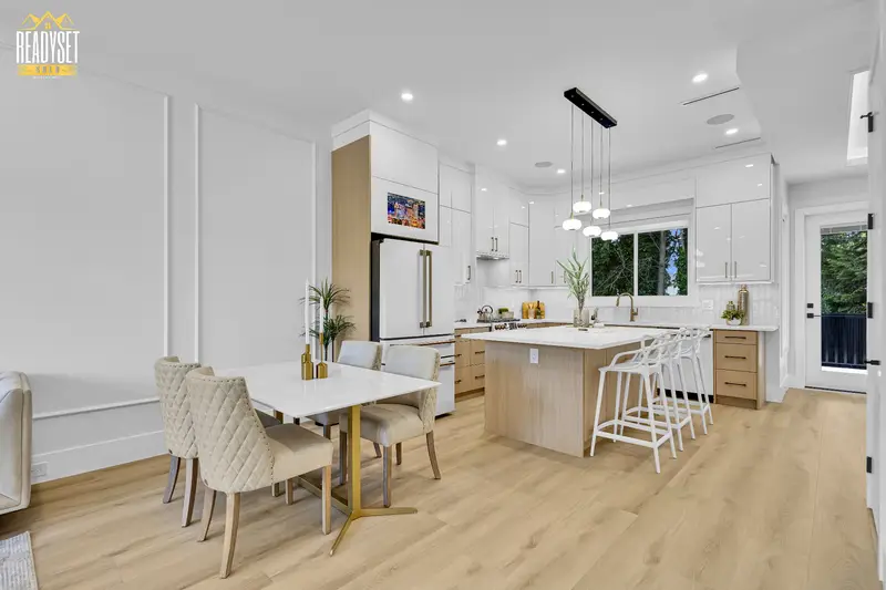 Bright dining area and chef kitchen with gold accents in a North Delta duplex listing