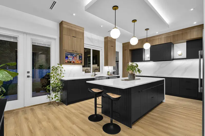 Modern kitchen with marble island, black cabinetry and wood accents