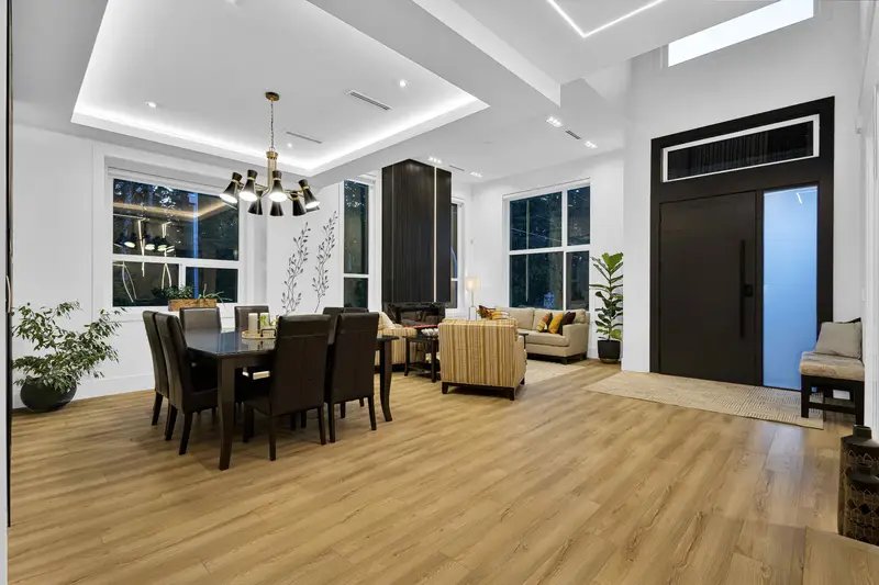 Bright dining area and foyer with chandelier and feature wall in Langley listing