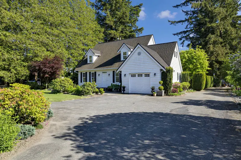 Daytime front exterior with attached garage of a Langley detached home