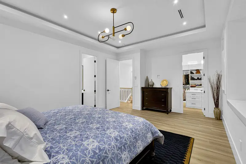 Primary bedroom with tray ceiling and walk-in closet in Langley luxury home