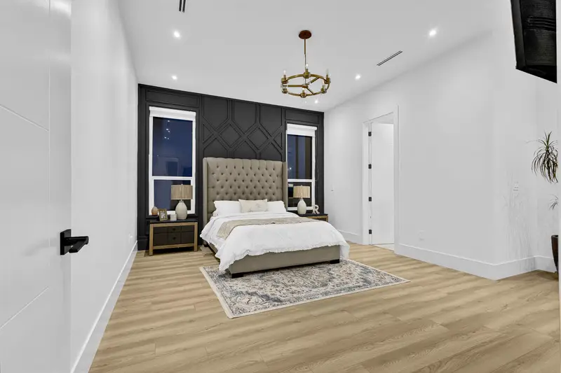 Elegant bedroom with tufted headboard and dark wainscot accent wall