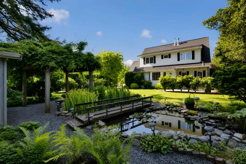 Backyard pond and wooden bridge at a Langley detached home