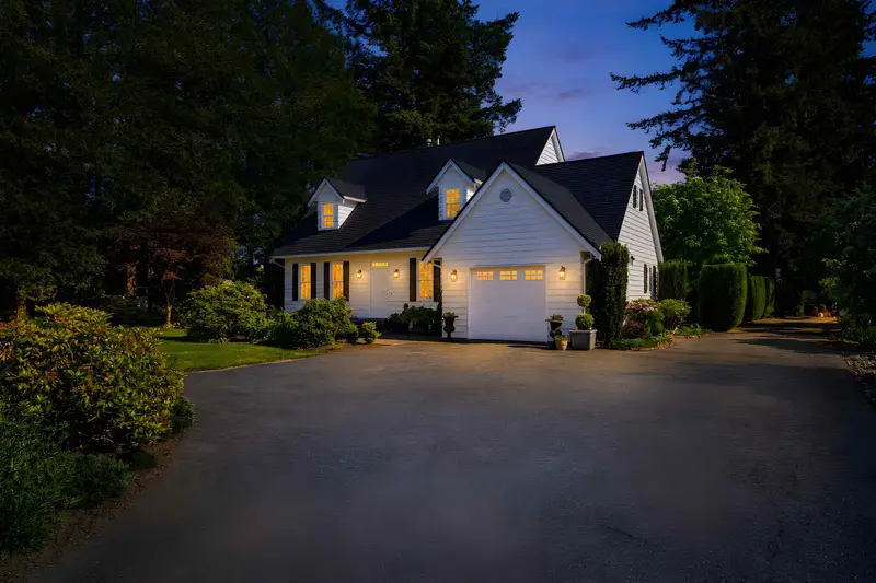 Twilight side exterior of a Langley detached home with warm interior lighting