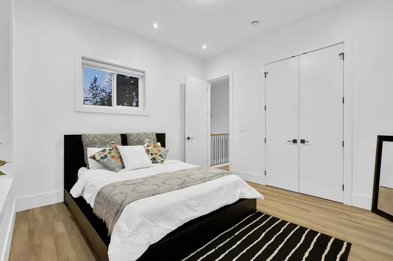 Spacious bedroom with double closet doors and natural light in Langley listing